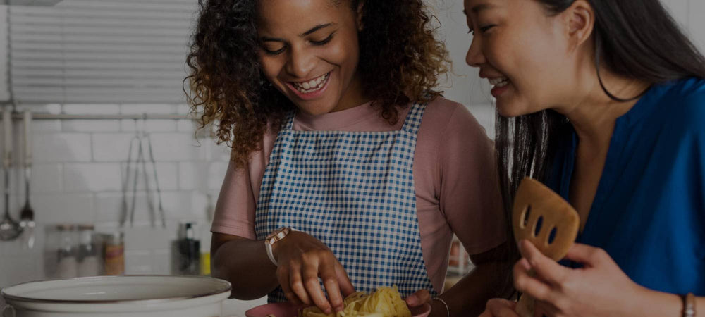 Two teenage girls preparing food in a kitchen - CleanSmart Canada